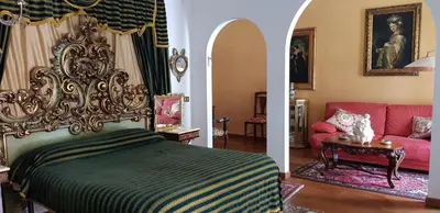 two pictures of a bedroom with a bed and a couch at Palazzo Viola Suite Panoramica Palermo in Palermo