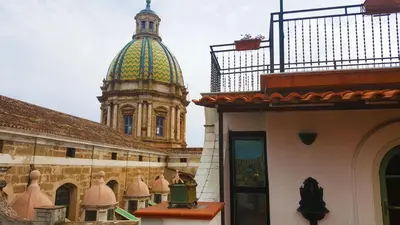 a building with a clock tower in the background at Palazzo Viola Suite Panoramica Palermo in Palermo