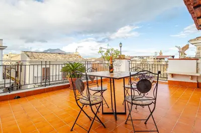 a patio with a table and chairs on a balcony at Palazzo Viola Suite Panoramica Palermo in Palermo