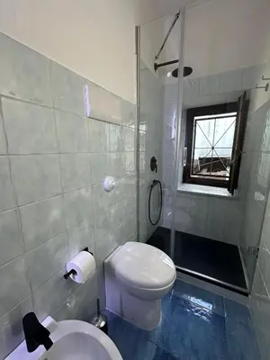 a bathroom with a white toilet and a shower at Massimo Boutique Apartment in Palermo
