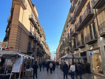 a group of people walking down a street with buildings at Massimo Boutique Apartment in Palermo