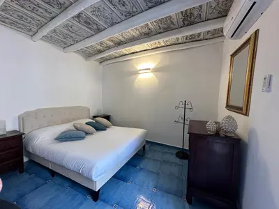 a bedroom with a bed with blue pillows on it at Massimo Boutique Apartment in Palermo