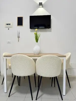 a dining room table with chairs and a vase of flowers at Tra i Vicoli del Capo in Palermo