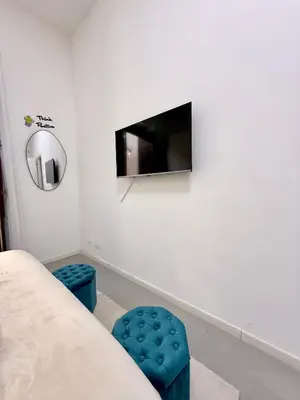 a living room with a tv and two blue stools at Tra i Vicoli del Capo in Palermo