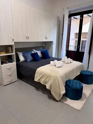 a bedroom with a large bed with blue pillows at Tra i Vicoli del Capo in Palermo