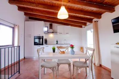 a kitchen and dining room with a white table and chairs at I tre Mori in Monreale