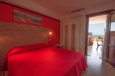 a red bedroom with a bed with a red blanket at A Casa di Amy in Macari