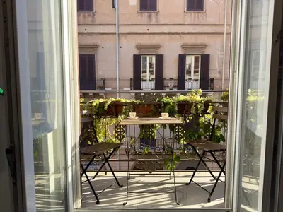 an open window with a table and chairs on a balcony at Casa Faidda in Palermo