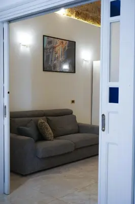a living room with a couch and a picture on the wall at Casa Faidda in Palermo