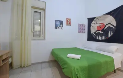 a small bedroom with a bed with a green blanket at Stunning Apartment In Palermo With Wifi in Palermo