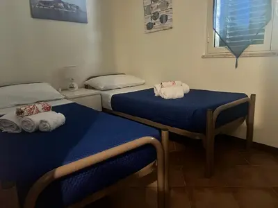 two beds in a room with blue sheets and towels at Casa sul mare Lalu a 20 kl da Palermo e 30 da Cefalu tre camere 9 posti in Santa Flavia