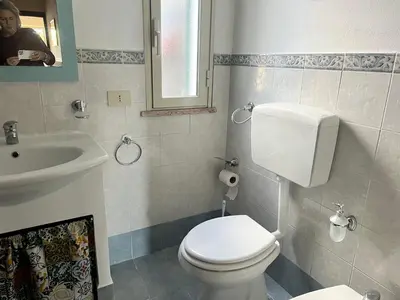 a bathroom with a white toilet and a sink at Casa sul mare Lalu a 20 kl da Palermo e 30 da Cefalu tre camere 9 posti in Santa Flavia