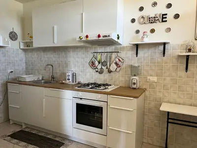 a kitchen with white cabinets and a stove top oven at Casa sul mare Lalu a 20 kl da Palermo e 30 da Cefalu tre camere 9 posti in Santa Flavia