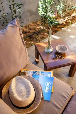 a straw hat sitting on a couch next to a table at Blu House in Terrasini