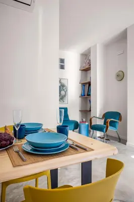 a dining room with a table with blue plates and chairs at Blu House in Terrasini