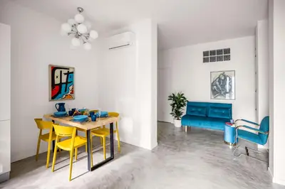 a dining room with a table and yellow chairs at Blu House in Terrasini