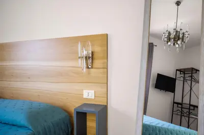a bedroom with a wooden headboard and a blue stool at Blu House in Terrasini