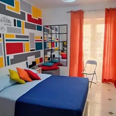 a bedroom with a blue bed with colorful pillows at Casa Sarina in Monreale