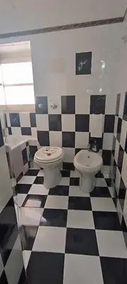 a bathroom with two toilets and a checkered floor at Casa Sarina in Monreale