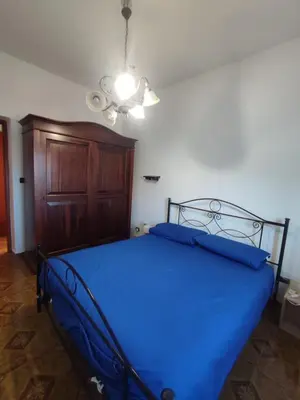 a bedroom with a blue bed with a ceiling fan at Casa vacanze balestrate in Balestrate