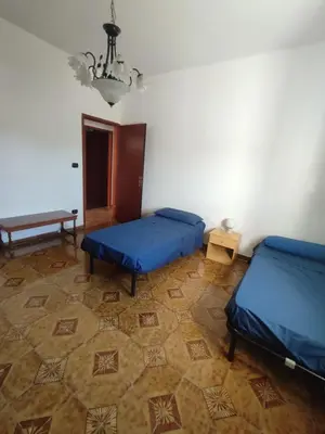 a room with two beds and a table at Casa vacanze balestrate in Balestrate