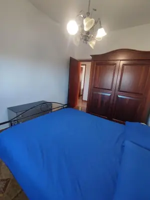 a bedroom with a blue bed and a wooden cabinet at Casa vacanze balestrate in Balestrate