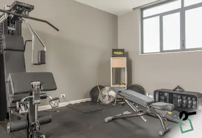 a room with a gym with a bench and a treadmill at HOTIDAY Mondello Beach in Mondello