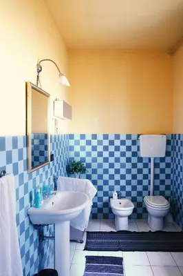 a blue and white bathroom with a sink and a toilet at In Torre Palazzo Orioles in Palermo