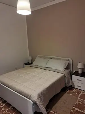 a bedroom with a bed with two night stands and two lamps at Casa Kennedy in Capaci