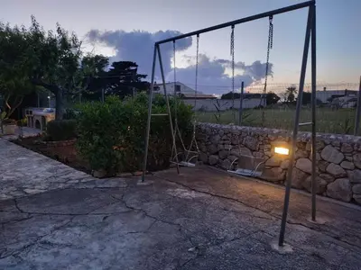 a swing set with a light on a stone wall at Casa vacanze mare Rosa in Castellammare del Golfo