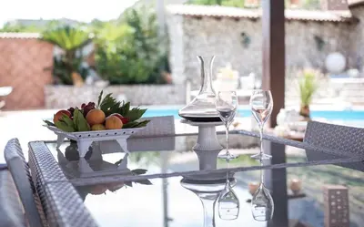 a table with two wine glasses and a bowl of fruit at Villa Aversa in Castellammare del Golfo