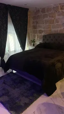 a bedroom with a large black bed with a window at Ai Chiavettieri Suite in Palermo