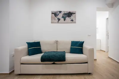 a white couch with blue pillows in a living room at Dominic Luxury House - a 2 passi dalla cattedrale in Palermo