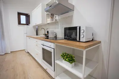 a kitchen with white cabinets and a counter with a microwave at Dominic Luxury House - a 2 passi dalla cattedrale in Palermo