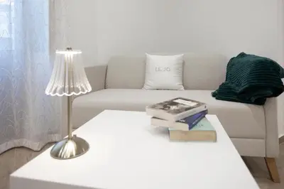 a living room with a white couch and a table with a lamp at Dominic Luxury House - a 2 passi dalla cattedrale in Palermo