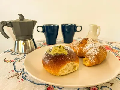two rolls and croissants on a plate on a table at B&B Il Mare di Terrasini in Terrasini
