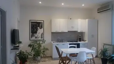 a kitchen with a table and chairs and a kitchen with a table and a table at Appartamento Cantieri-Porto,Palermo in Palermo