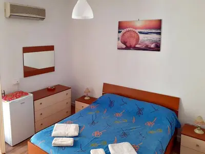 a bedroom with a bed with a blue comforter at Don Vito's Apartments in Castellammare del Golfo
