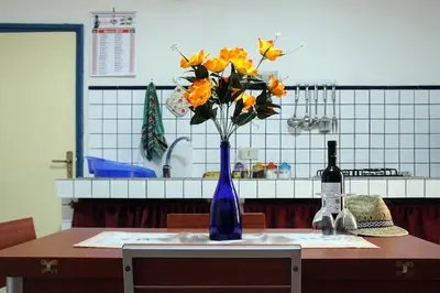 a blue vase with orange flowers on a table at Don Vito's Apartments in Castellammare del Golfo