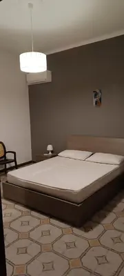 a bedroom with a large bed with a white sheet at Casa la B a n d i t a in Palermo