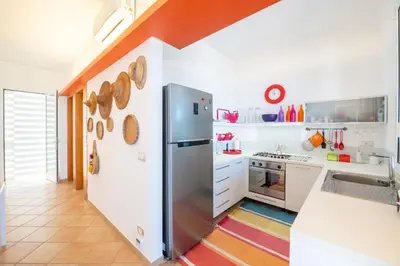 a kitchen with a stainless steel refrigerator and white cabinets at La Bougainvillea casa vacanze in Alcamo