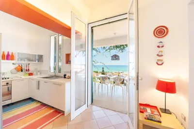 a kitchen with a view of the ocean at La Bougainvillea casa vacanze in Alcamo