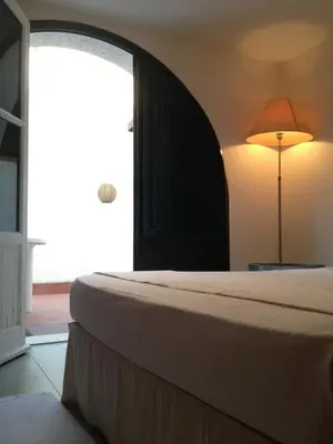 a bedroom with a bed and a lamp and a window at Casa Mamma Bruna in San Vito lo Capo