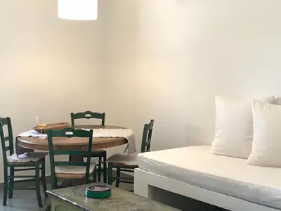 a room with a table and a bed and a table and chairs at Casa Mamma Bruna in San Vito lo Capo