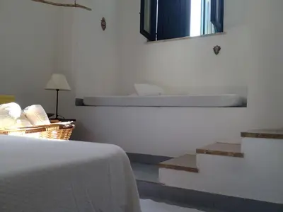 a bedroom with a bed and a mirror on the wall at Casa Mamma Bruna in San Vito lo Capo