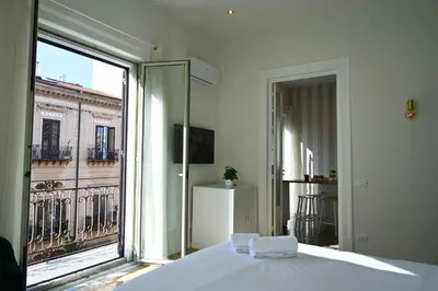 a bedroom with a bed and a large window at Chez Moi in Palermo