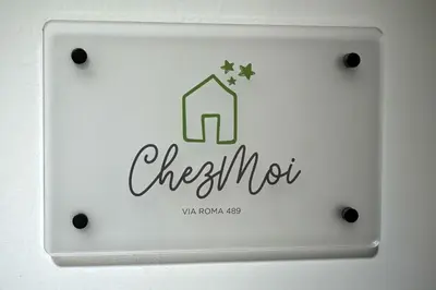 a lightswitch on a wall with the words check out at Chez Moi in Palermo