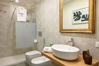 a bathroom with a sink and a toilet and a mirror at Chez Moi in Palermo