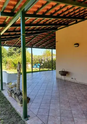an open patio with a wooden roof and a table at Casa delle Salinelle in Lascari
