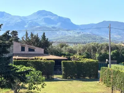 a view of a house with mountains in the background at Casa delle Salinelle in Lascari